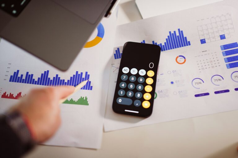 Calculator and financial charts on a desk, planning a website budget